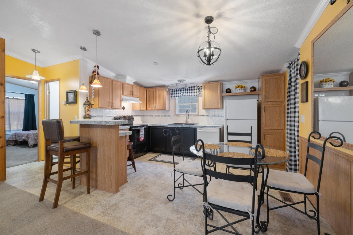 3307 Sunset Cliff Road Burnet, TX 78611 - Photo 16 of 23 a kitchen with stainless steel appliances kitchen island granite countertop a table chairs and a refrigerator