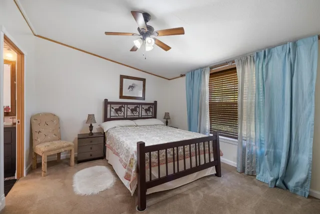 a bedroom with a bed chandelier and a window