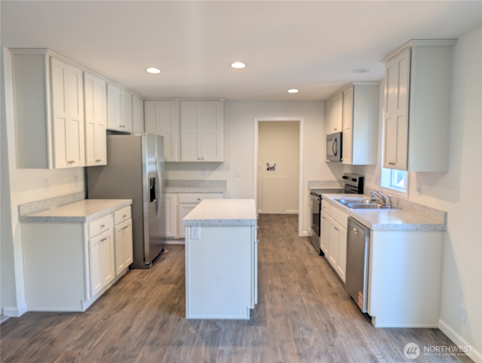 4000 Flynn Street, Unit 33 Bellingham, WA 98229 - Photo 5 of 15 a kitchen with kitchen island wooden floors appliances and cabinets