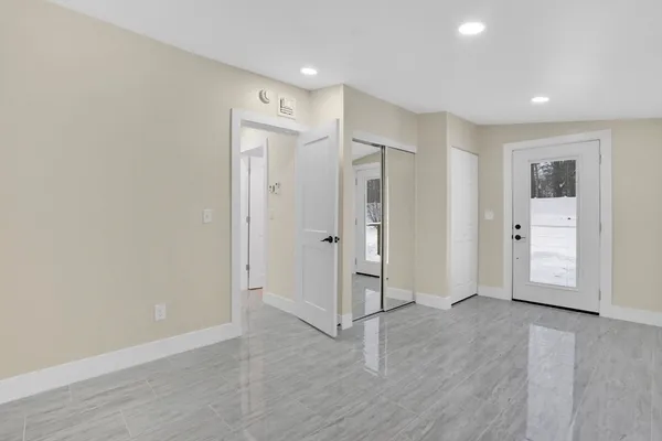 an empty room with wooden floor and window
