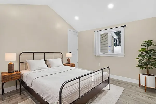 a bedroom with bed and paintings on the wall