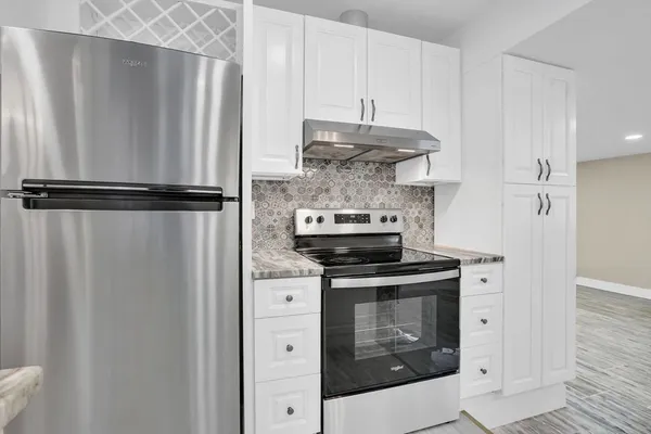 a kitchen with stainless steel appliances granite countertop a sink stove and refrigerator