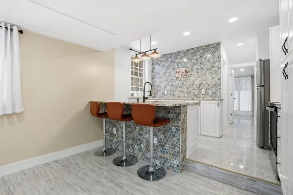 a kitchen with stainless steel appliances kitchen island granite countertop a refrigerator and a stove