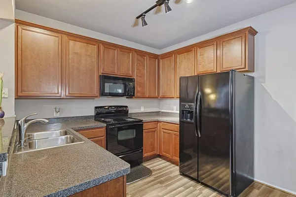 a kitchen with granite countertop a refrigerator stove and sink