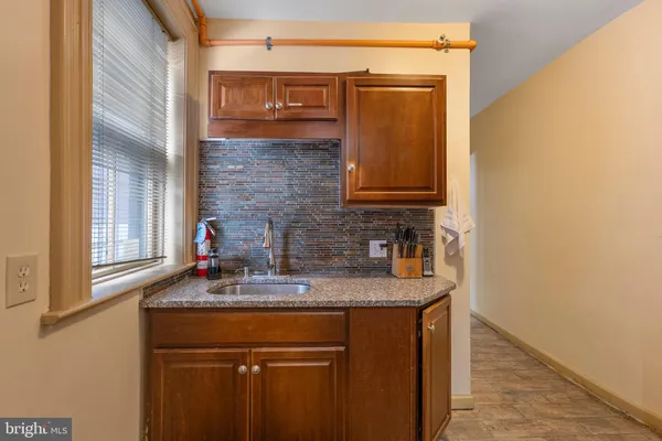 a bathroom with a granite countertop sink and a mirror
