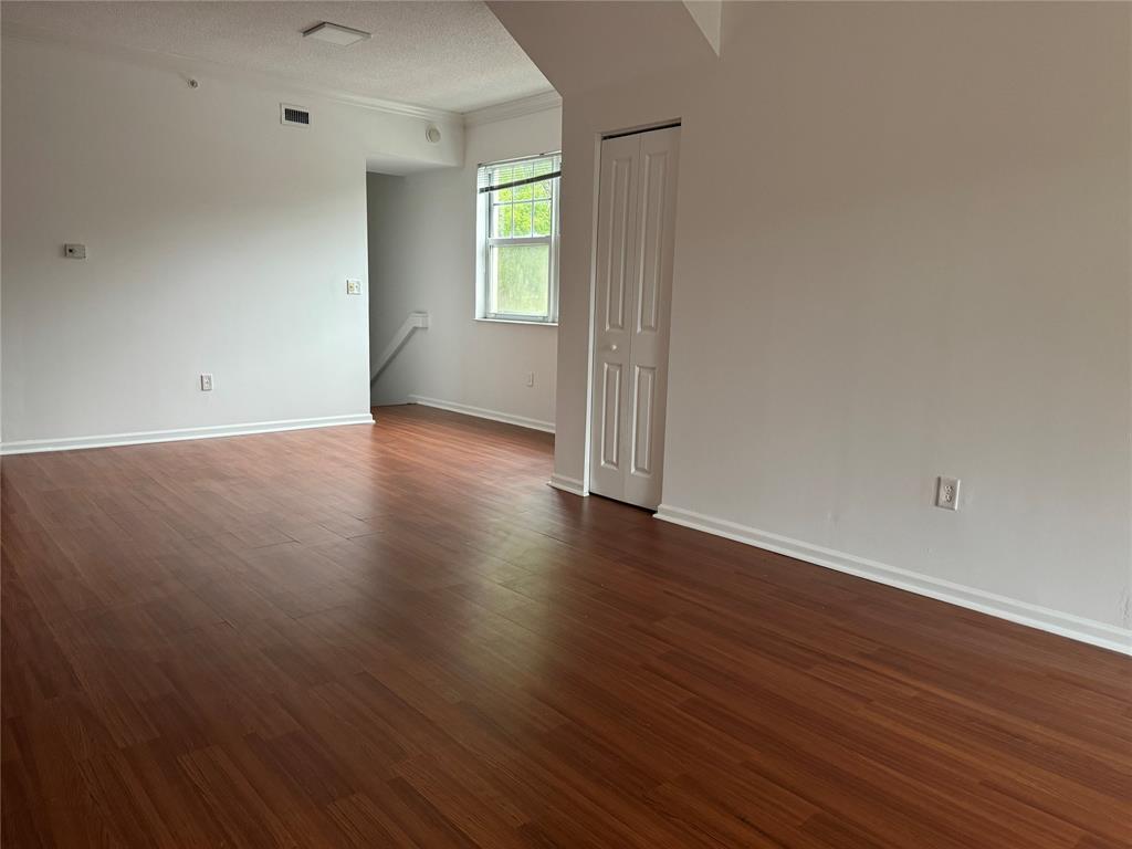 5800 West Sample Road, Unit 2011 Coral Springs, FL 33067 - Photo 12 of 25 an empty room with wooden floor and windows