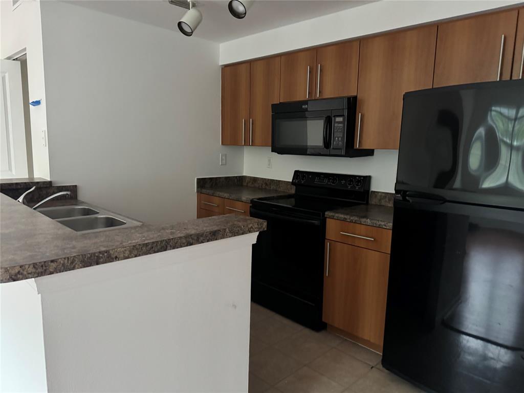 5800 West Sample Road, Unit 2011 Coral Springs, FL 33067 - Photo 13 of 25 a kitchen with a sink and a microwave