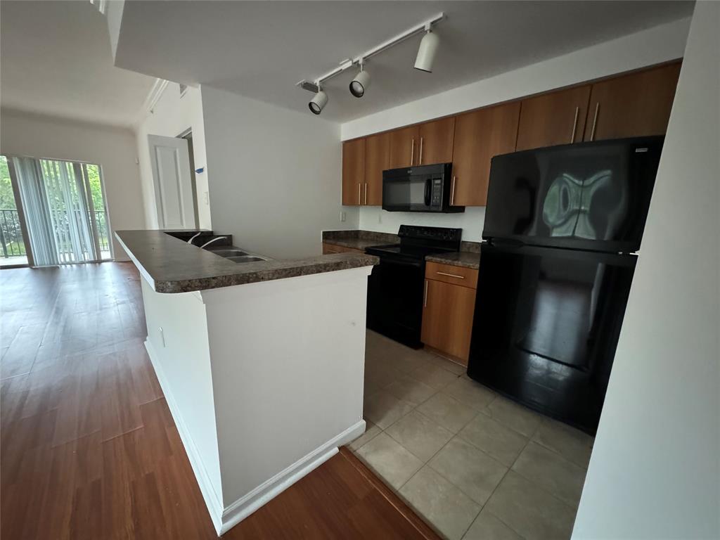 5800 West Sample Road, Unit 2011 Coral Springs, FL 33067 - Photo 14 of 25 a kitchen with stainless steel appliances granite countertop a refrigerator a stove top oven a sink and dishwasher