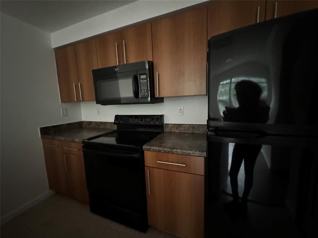 5800 West Sample Road, Unit 2011 Coral Springs, FL 33067 - Photo 19 of 25 a kitchen with a stove microwave and sink