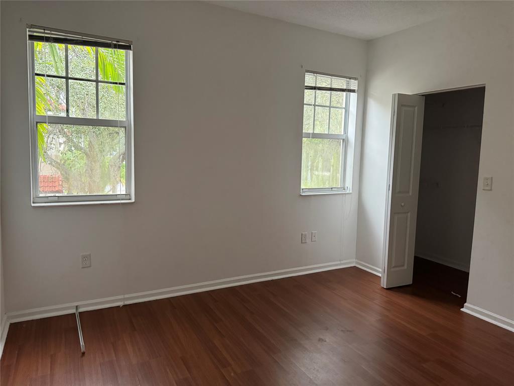 5800 West Sample Road, Unit 2011 Coral Springs, FL 33067 - Photo 21 of 25 an empty room with wooden floor and windows