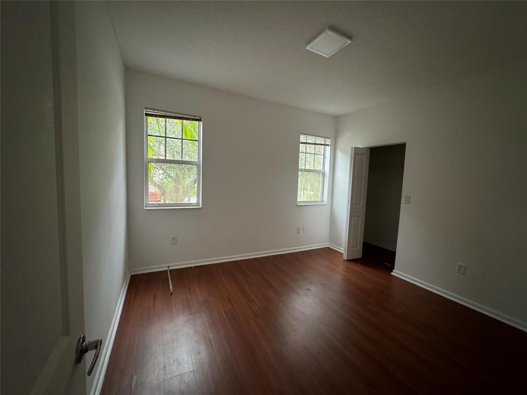 5800 West Sample Road, Unit 2011 Coral Springs, FL 33067 - Photo 22 of 25 an empty room with wooden floor and windows