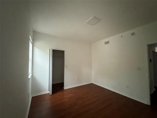 an empty room with wooden floor and closet