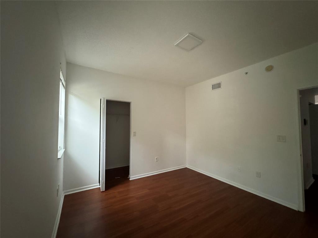 5800 West Sample Road, Unit 2011 Coral Springs, FL 33067 - Photo 23 of 25 an empty room with wooden floor and closet