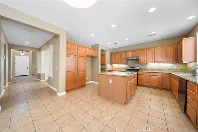 a large kitchen with a large counter top stainless steel appliances and cabinets
