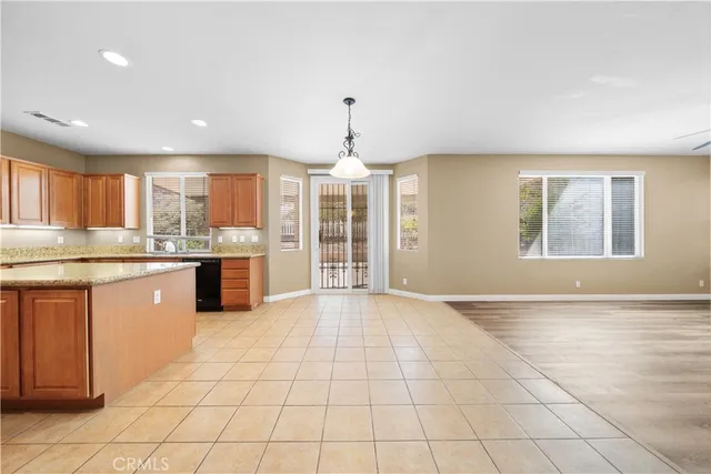 a large kitchen with granite countertop a stove a sink dishwasher and a refrigerator