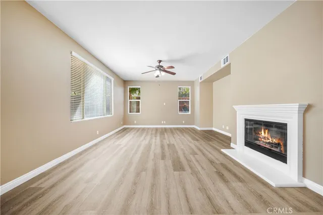 a view of empty room with wooden floor and fireplace