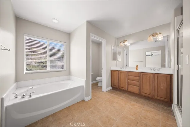 a spacious bathroom with a tub sink shower and mirror