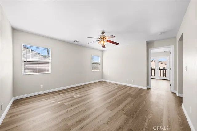 a view of a livingroom with wooden floor and a ceiling fan
