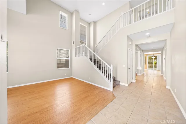 a view of an entryway with wooden floor leading to a furnished livingroom and windows