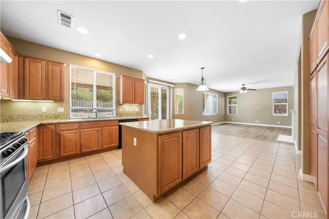 a large kitchen with stainless steel appliances granite countertop a stove a sink and a refrigerator