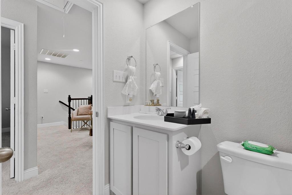 6040 Bursey Road Watauga, TX 76148 - Photo 21 of 39 a bathroom with a sink a toilet and a mirror