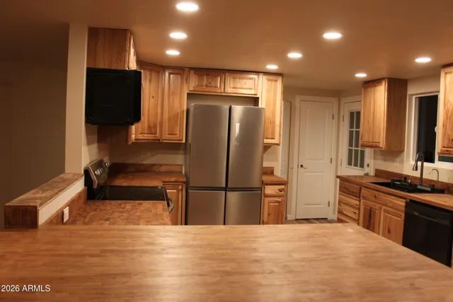 a kitchen with stainless steel appliances granite countertop a refrigerator and a sink