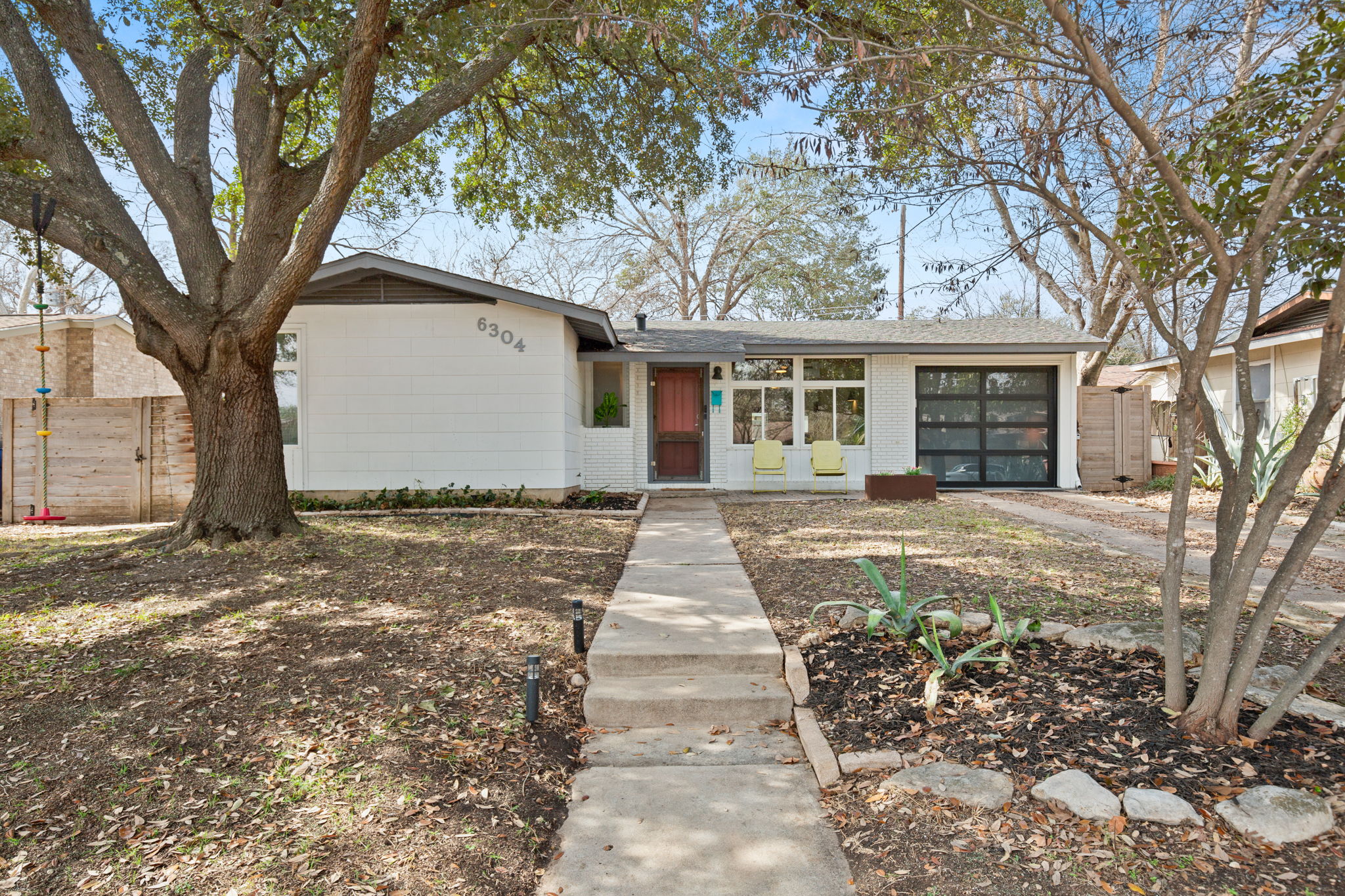 6304 Peggy Street Austin, TX 78723 - Photo 24 of 35 View of front of house featuring brick siding, a garage, and driveway
