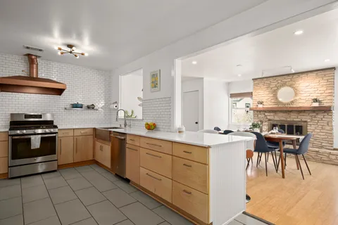 a kitchen with a stove window and cabinets