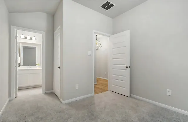 an empty room with closet and a bathroom