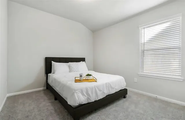 a large bed sitting in a bedroom next to a window