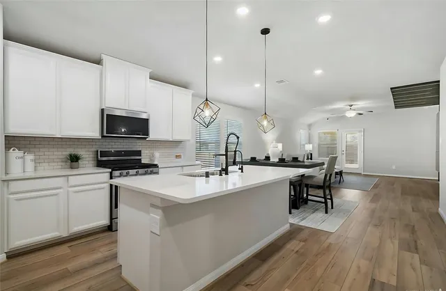 a large kitchen with kitchen island a sink and a stove top oven