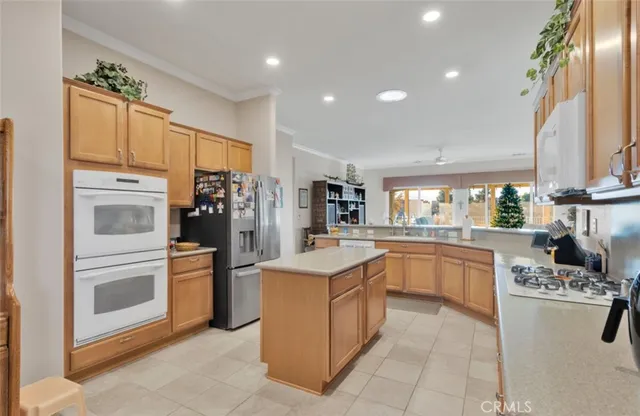 a kitchen with stainless steel appliances granite countertop a refrigerator and a stove top oven