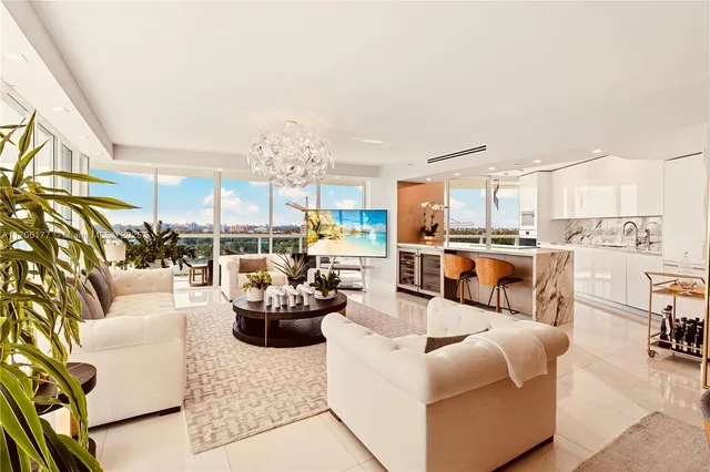 a living room with furniture kitchen view and a large window