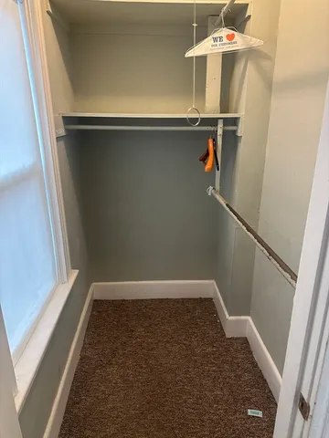 a view of walk in closet with clothes