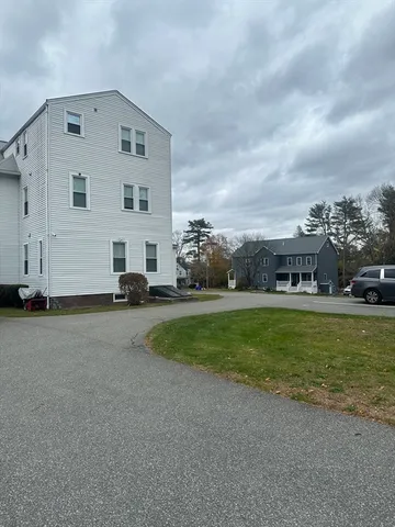 a view of a big house with a big yard and large trees