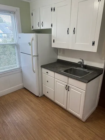 a kitchen with granite countertop white cabinets and white appliances