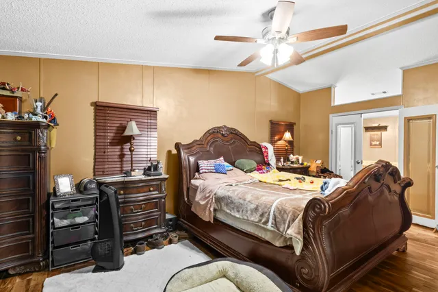 a bedroom with a bed and wooden floor