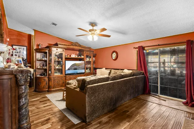 a living room with furniture a flat screen tv and a floor to ceiling window