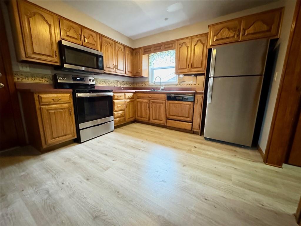 414 Marion Street Creighton, PA 15030 - Photo 8 of 23 a kitchen with stainless steel appliances granite countertop a refrigerator stove a sink dishwasher and microwave with wooden floor