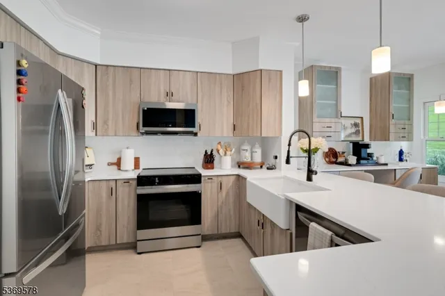 a kitchen with stainless steel appliances a stove a sink a refrigerator and a oven