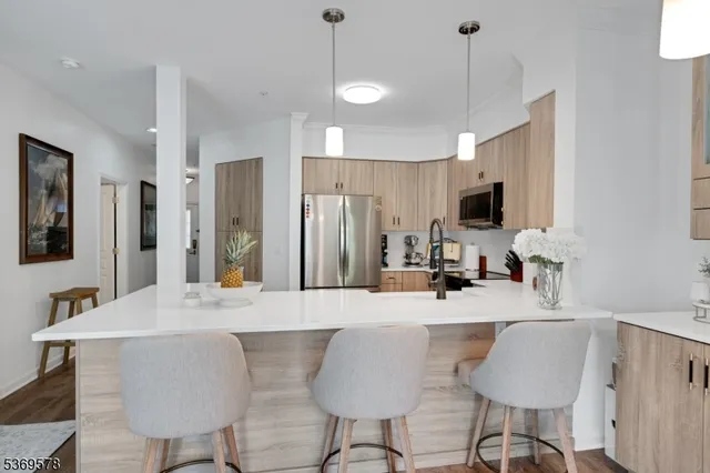 a kitchen with kitchen island granite countertop a sink and a refrigerator