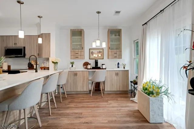 a kitchen with kitchen island granite countertop a table chairs sink and refrigerator