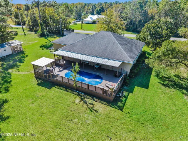 an aerial view of a house with swimming pool garden and patio