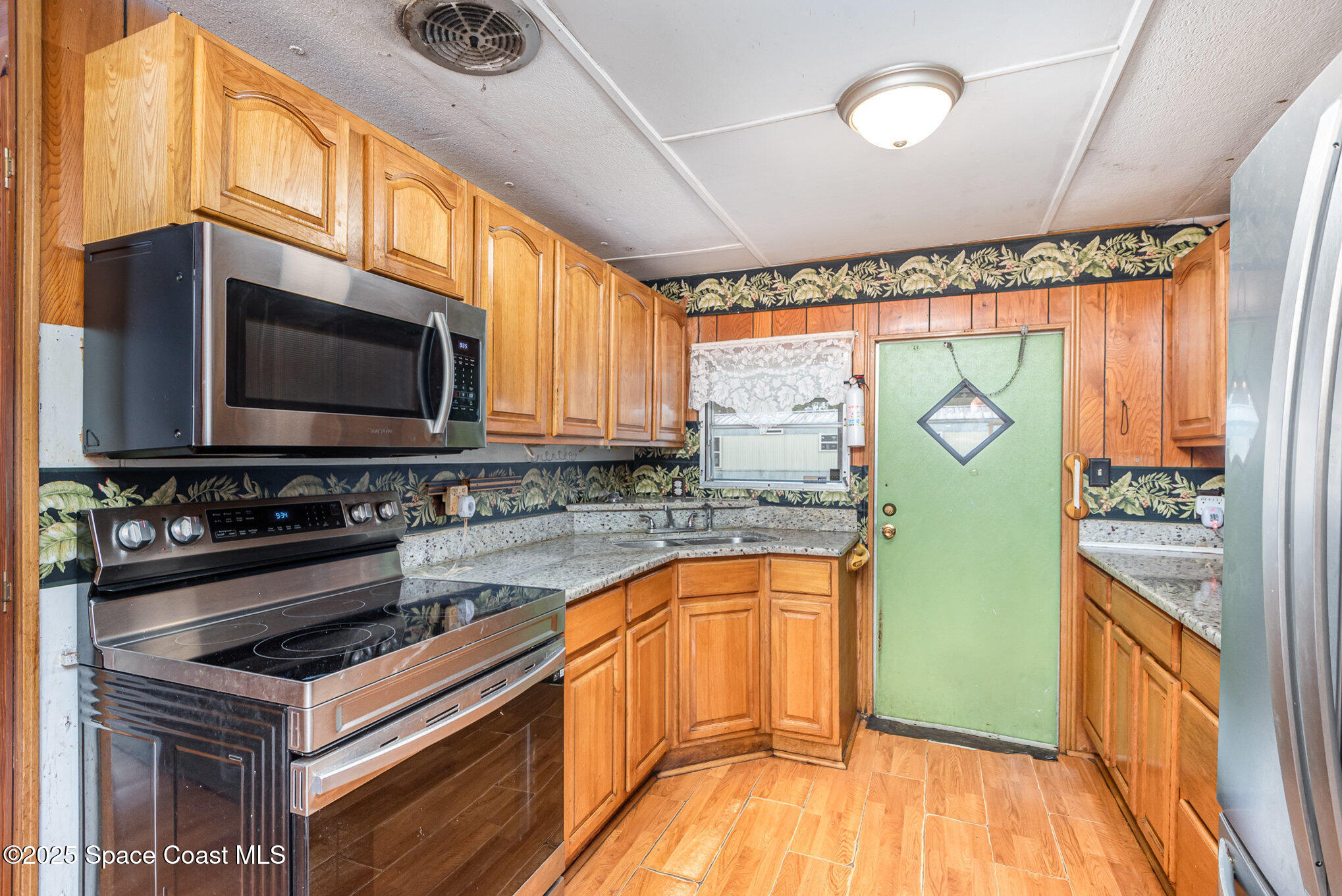 3083 Dover Road Mims, FL 32754 - Photo 3 of 18 a kitchen with stainless steel appliances a stove a sink and a microwave