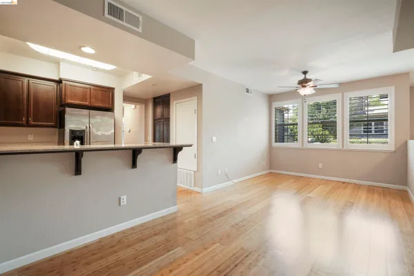 a view of an empty room with a window and wooden floor