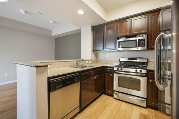 a kitchen with stainless steel appliances granite countertop a stove microwave and sink