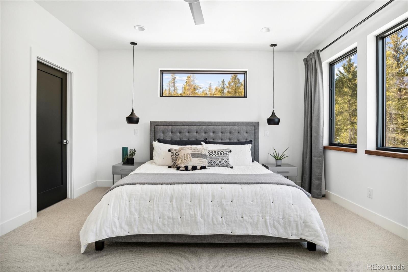 10199 Christopher Drive Conifer, CO 80433 - Photo 12 of 40 a bedroom with a bed lamp and a window