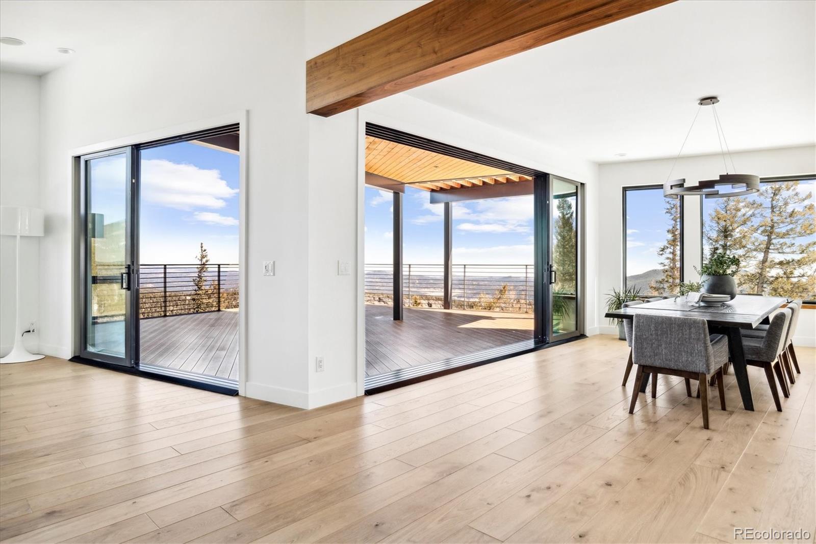 10199 Christopher Drive Conifer, CO 80433 - Photo 25 of 40 a view of a dining room with furniture large windows and wooden floor