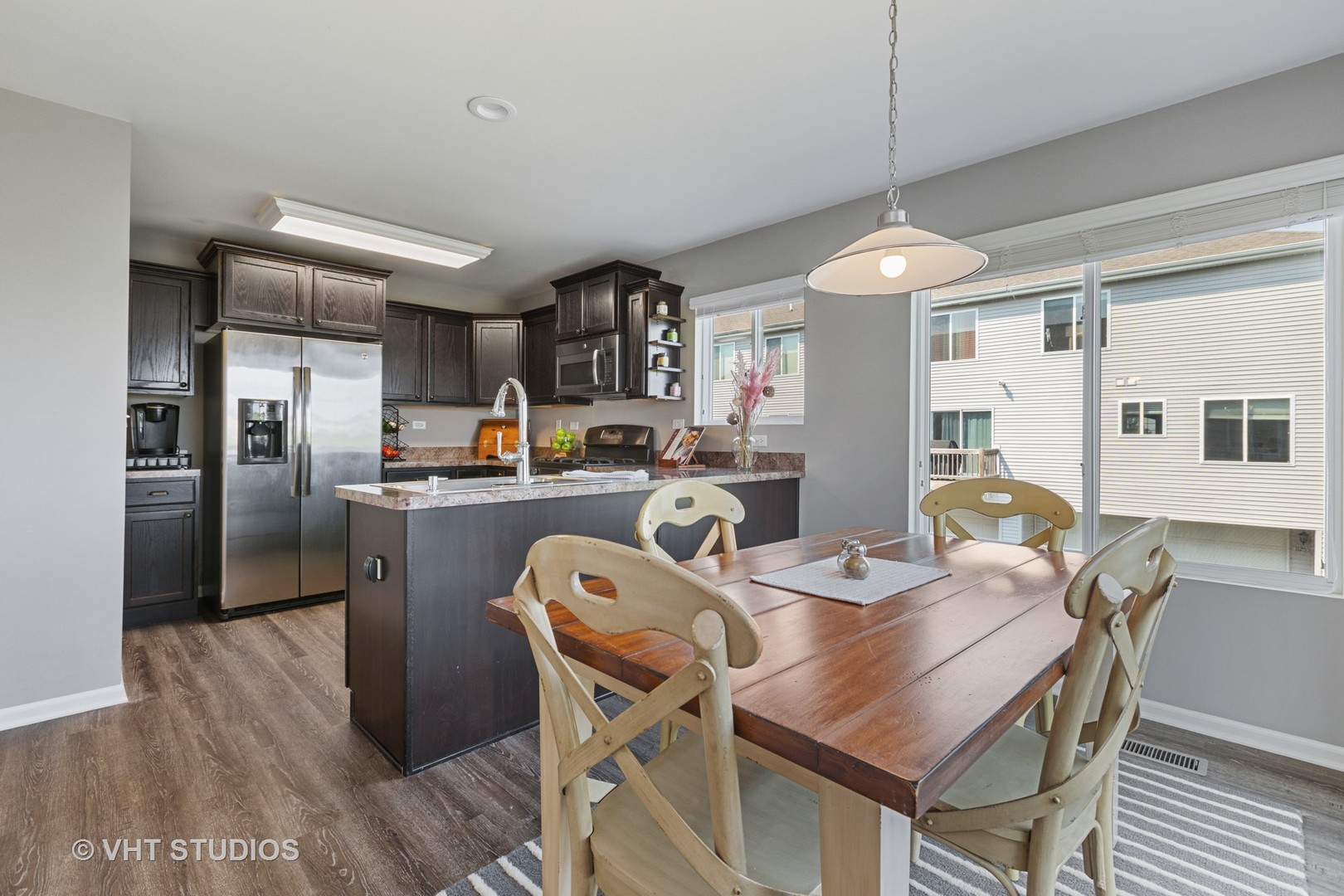 1141 Piccolo Lane Volo, IL 60073 - Photo 5 of 29 a kitchen with stainless steel appliances granite countertop a dining table chairs refrigerator and wooden floor