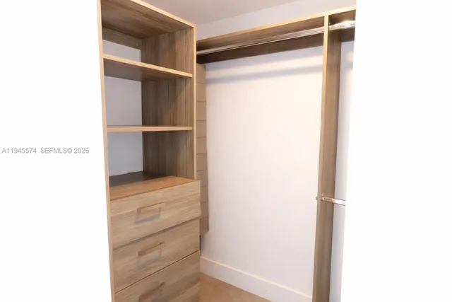 a view of walk in closet with empty racks